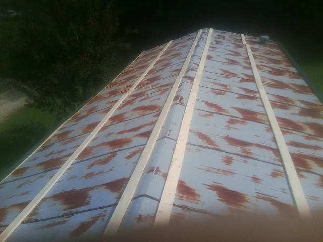 Rusted metal roof panels with new wood purlins before replacement — Storm Damage Roof Repair in Harpursville by Roofing Brothers