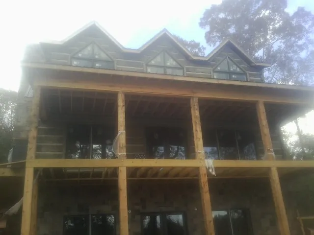 Dormers and porch framing on a large log home under construction in Harpursville
